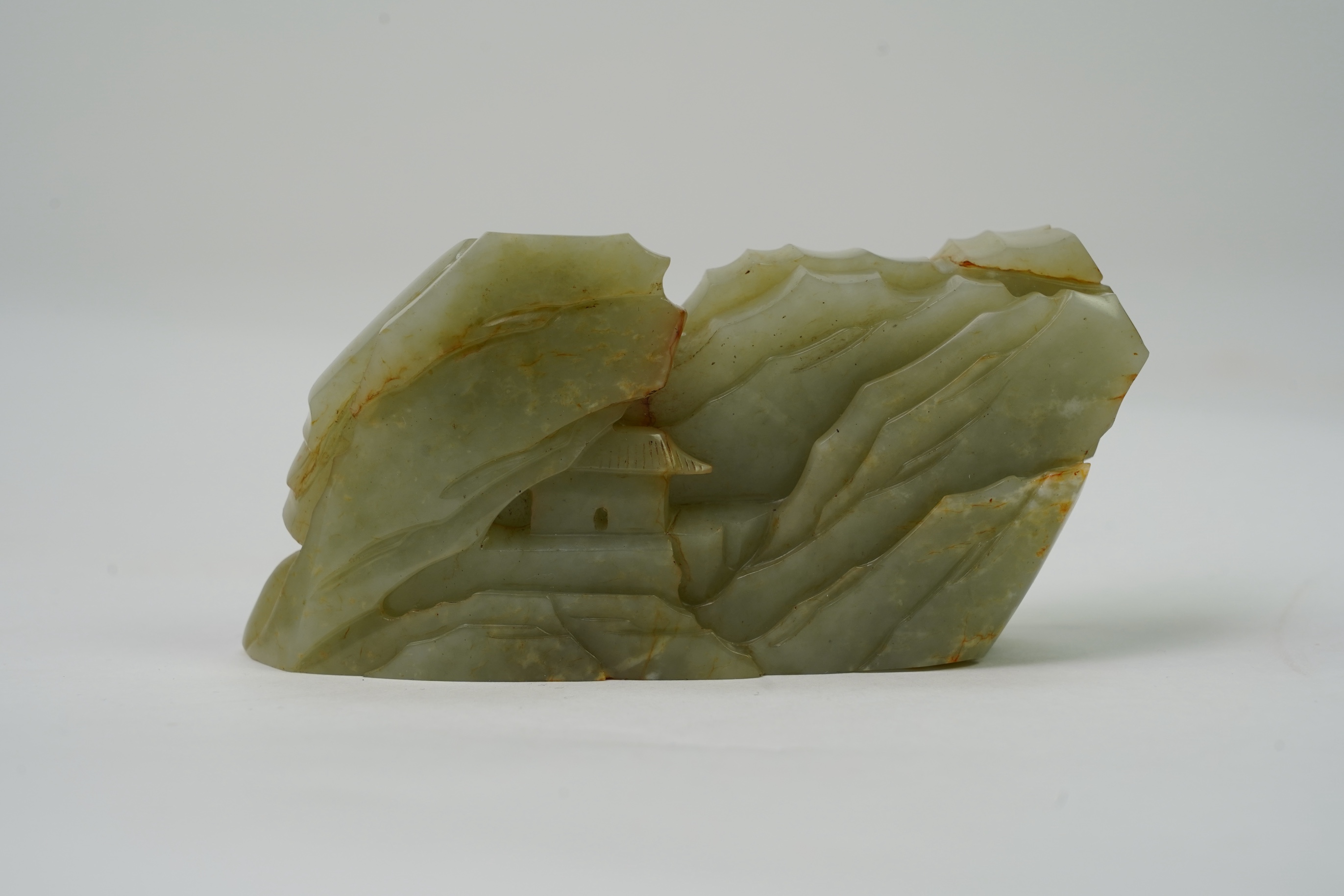 A Chinese celadon and russet jade boulder carving
